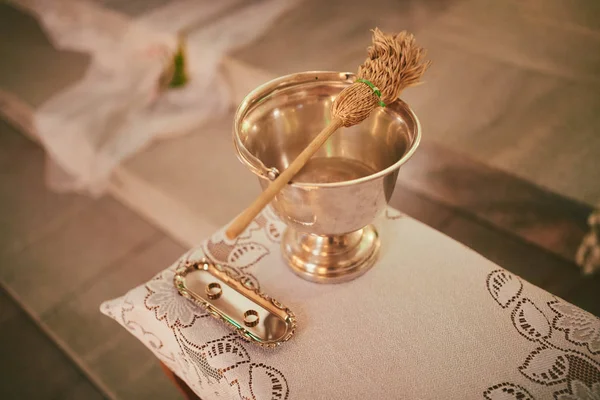 Aspersor de água benta de ouro na igreja católica. ferramentas para aspersão na igreja — Fotografia de Stock