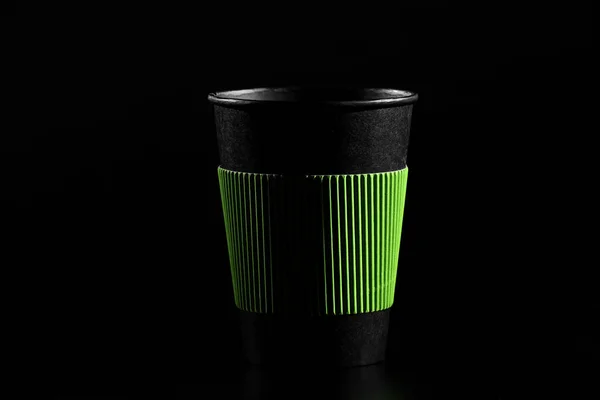 Um copo de chá quente ou café. Vidro de papel preto com uma tampa sobre um fundo preto. vista lateral — Fotografia de Stock