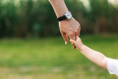 Baba çocuğun elinden tutar. bir yürüyüş ve doğa