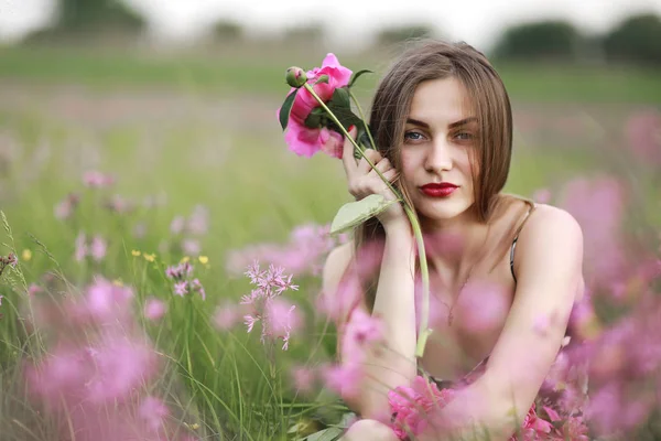 Piękny portret dziewczynki z różowe kwiaty. Dziewczyna w dziedzinie kwiaty. Bordowy Piwonia, krajobraz — Zdjęcie stockowe
