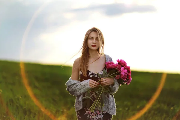 Ragazza nel campo dei fiori. ritratto di una ragazza con fiori rosa — Foto Stock