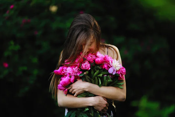 Ragazza nel campo dei fiori. ragazza abbraccia un mazzo di fiori. Bouquet di Peonia — Foto Stock