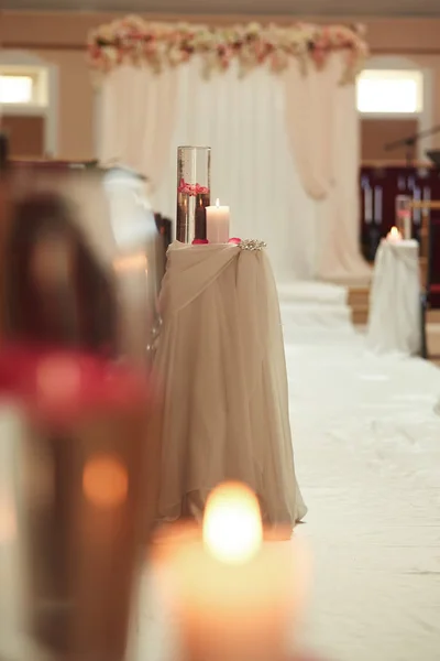 Decoración de la boda una vela y un jarrón con agua en una mesa blanca. Frascos con agua y una vela flotante — Foto de Stock