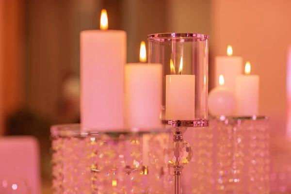 Velas en un candelero de vidrio. Vela ardiente en un candelabro de vidrio redondo con conchas decorativas — Foto de Stock