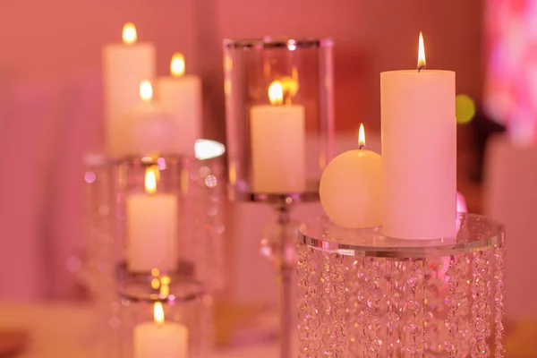 Velas en un candelero de vidrio. Vela ardiente en un candelabro de vidrio redondo con conchas decorativas — Foto de Stock