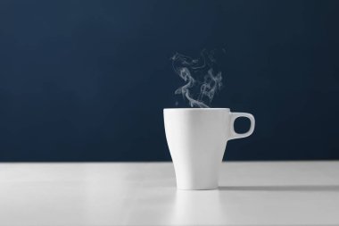 fincan çay buharla. sıcak çay beyaz bir daire içinde. mavi zemin üzerine sıcak kahve