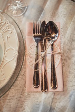 Servis, masa ayarlama. plakalar ve gümüş çatal keten peçete şeritler ile dekore edilmiştir. Düğün masası dekorasyonu. Sanat. düz yatıyordu. üst görünüm. boş plaka kaşık çatal ve bıçak masada