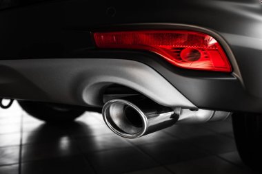 car exhaust pipe. Exhaust pipe of a luxury car. details of stylish car interior, leather interior. Close up clipart