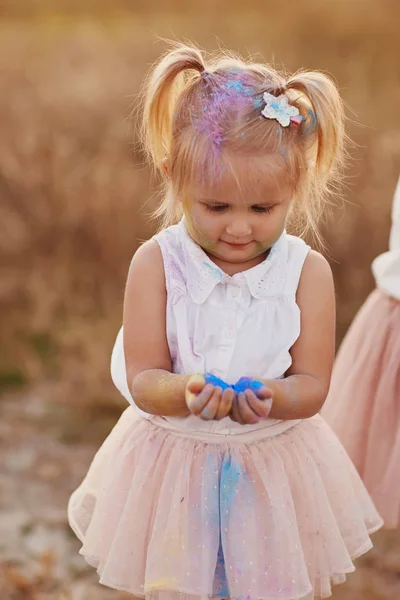 Retrato de chica feliz untado con polvo de colores. niña con dos colas — Foto de Stock