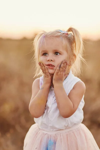 컬러 파우더로 얼룩진 행복한 소녀의 초상화. 두 개의 꼬리를 가진 어린 소녀 — 스톡 사진