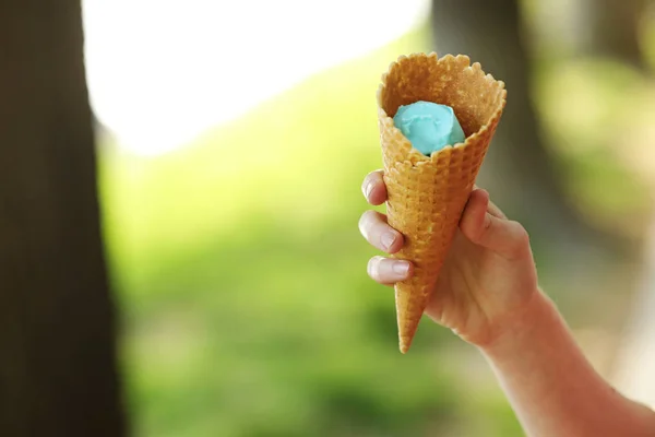 Женщина держит вафельный конус с голубым мороженым. Закрыть, продукт высокого разрешения. голубое мороженое в руке . — стоковое фото