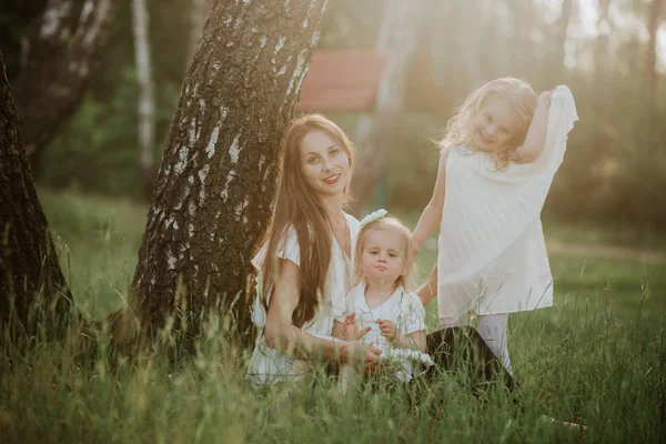 Bonne mère et deux filles dans le parc. Beauté scène de nature avec style de vie familial en plein air. famille ensemble — Photo