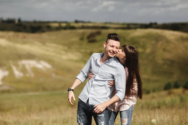 Jong koppel buiten portret. mooi mooi meisje kussen knappe jongen. sensuele foto. — Stockfoto