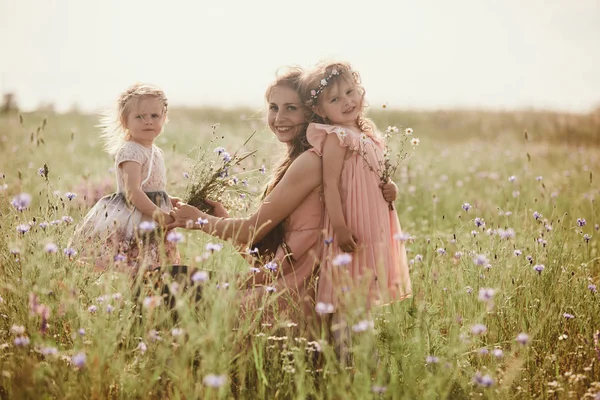 Vacker mor och hennes lilla dotter utomhus. Natur. Utomhus porträtt av lycklig familj. Skönhet mamma och hennes barn leker i parken tillsammans. Lycklig mors dag glädje. Mamma och baby — Stockfoto
