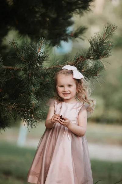 Портрет девушки на улице. Милая девушка, гуляющая по лесу. Удивительная маленькая девочка в платье забавно позирует на фоне природы . — стоковое фото