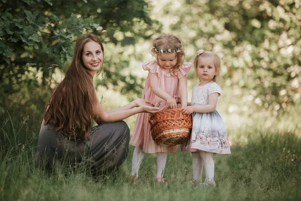 Photo de famille maman avec des filles dans le parc. Photo de jeune mère avec deux mignons enfants à l'extérieur au printemps, belle femme avec fille s'amuser — Photo
