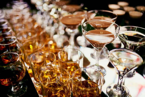 Gläser mit Cognac, Whiskeyständer an der Theke. Viele Gläser mit Cognac. Alkohol in der Brille. Verschiedene alkoholische Getränke stehen auf der Theke. Gläser mit Cognac auf der Theke — Stockfoto