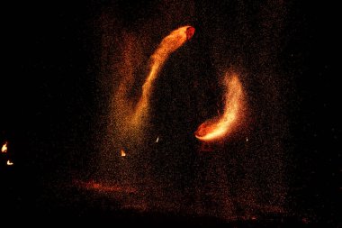 Ateş gösterisi, ateşle dans etmek, havai fişeklerle hokkabazlık yapan erkek üstat, açık havada gösteri, karanlıkta ateşli bir figür çizer, gece parlak kıvılcımlar. Takım elbiseli bir adam Ateşle dans ediyor.
