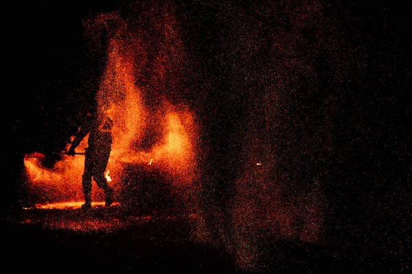 Show de fogo, dança com chama, mestre masculino malabarismo com fogos de artifício, desempenho ao ar livre, desenha uma figura ardente na escuridão, faíscas brilhantes na noite. Um homem de terno danças LED com fogo. — Fotografia de Stock