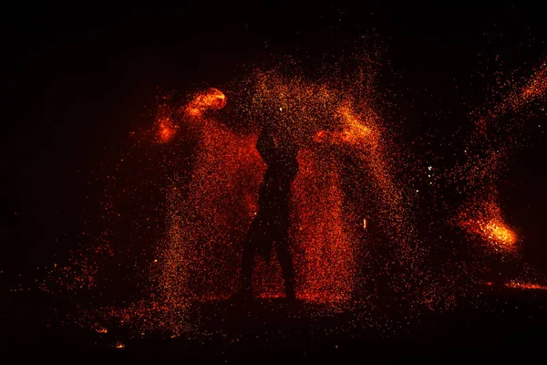 Pokaz ognia, taniec z płomieniem, mistrz żonglerka z fajerwerkami, występ na świeżym powietrzu, rysuje ognistą postać w ciemności, jasne iskry w nocy. Mężczyzna w garniturze LED tańczy z ogniem. — Zdjęcie stockowe