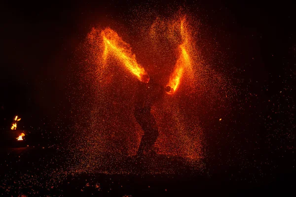 Pokaz ognia, taniec z płomieniem, mistrz żonglerka z fajerwerkami, występ na świeżym powietrzu, rysuje ognistą postać w ciemności, jasne iskry w nocy. Mężczyzna w garniturze LED tańczy z ogniem. — Zdjęcie stockowe