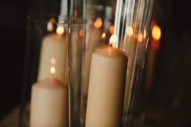 Evde ki koyu arka plana karşı bronz mumlar yakmak. Vintage tarzı. Sakin romantik bir atmosfer. Tasarım için yatay görüntü.