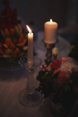 Evde ki koyu arka plana karşı bronz mumlar yakmak. Vintage tarzı. Sakin romantik bir atmosfer. Tasarım için yatay görüntü.