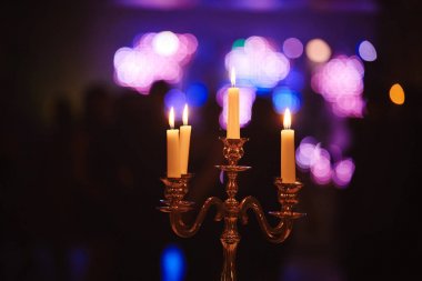 Evde ki koyu arka plana karşı bronz mumlar yakmak. Vintage tarzı. Sakin romantik bir atmosfer. Tasarım için yatay görüntü.