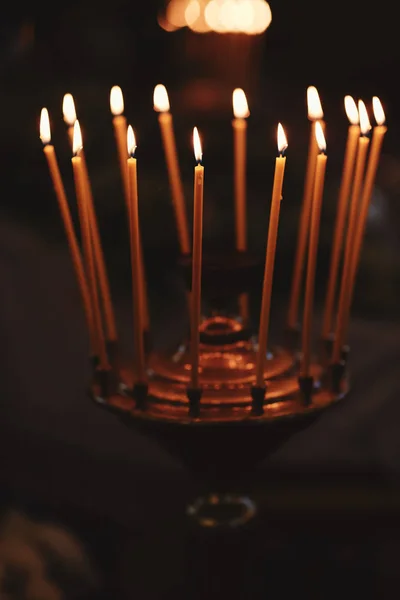 Brennende Kerzen auf Bronzekerzenständer vor dunklem Hintergrund zu Hause. Kerzen im Innenraum. Vintage-Stil. ruhige romantische Atmosphäre. horizontales Bild für Design. — Stockfoto