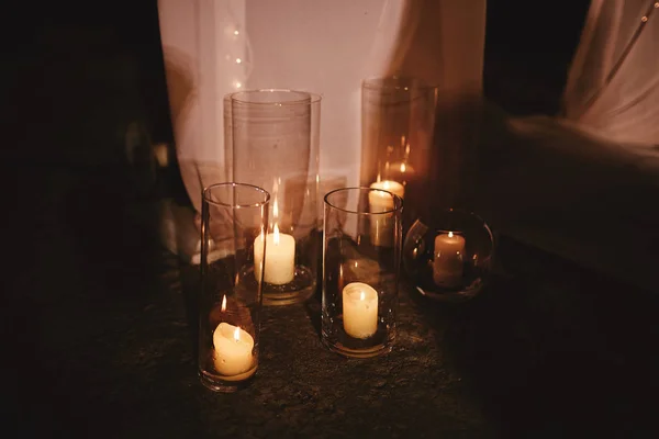 Queimar velas no castiçal de bronze contra fundo escuro em casa.velas no interior. Estilo vintage. Atmosfera romântica calma. Imagem horizontal para design . — Fotografia de Stock