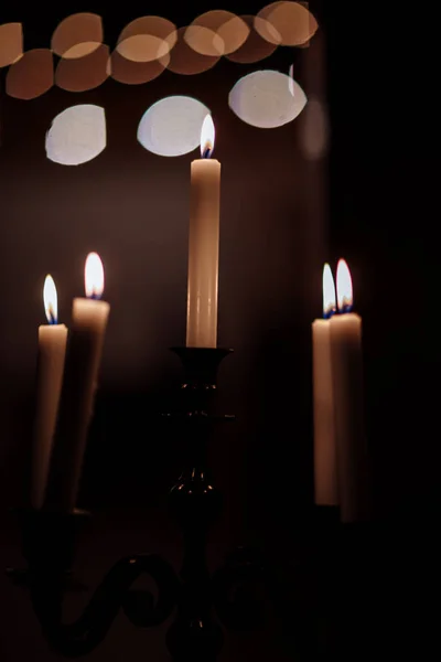 Velas ardientes sobre candelabro de bronce sobre fondo oscuro en casa.velas en el interior. Estilo vintage. Ambiente romántico tranquilo. Imagen horizontal para el diseño . — Foto de Stock