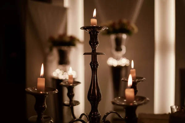 Brinnande ljus på brons ljusstake mot mörk bakgrund hemma. ljus i inredningen. Vintage stil. Lugn romantisk atmosfär. Horisontell bild för design. — Stockfoto