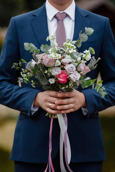 スタイリッシュな新郎はブライダル花束を保持しています。結婚式の花束で男の手 — ストック写真