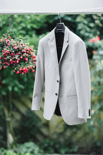 Traje gris novio de boda colgando en una percha por el árbol. Los preparativos en la mañana de la boda . —  Fotos de Stock