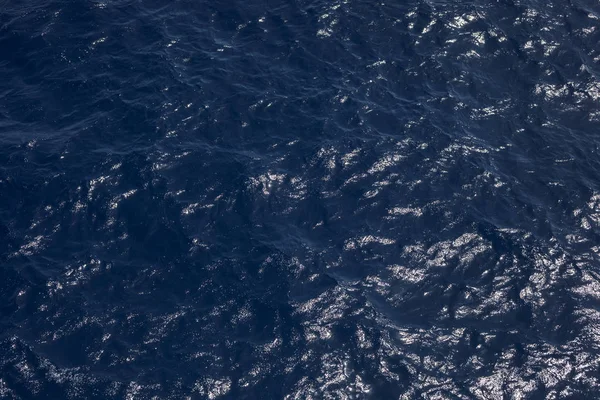 A superfície das ondas de água dos tons azuis como fundo. textura da água do mar. Terrenos é a superfície do fluxo de água a partir do fluxo de água para convergir . — Fotografia de Stock