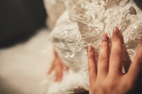 特写女人的手，抱着她婚纱，爱情和婚礼的概念。婚礼当天软和选择性对焦. — 图库照片