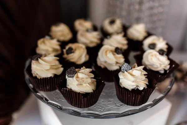 Pastelitos de chocolate. Magdalenas de chocolate caseras. El proceso de hacer magdalenas de chocolate caseras con crema batida y decoradas con chocolate. Enfoque selectivo. Concepto de barra de caramelo . — Foto de Stock