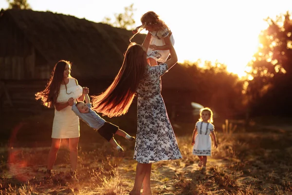 Jeunes mamans heureuses jouant avec leurs enfants à l'extérieur en été. Happy family time together concept. focus sélectif. — Photo