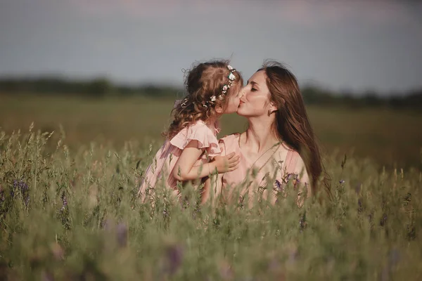 Joyeux famille : une jeune belle femme enceinte avec sa petite fille mignonne marchant dans le champ de blé par une journée d'été ensoleillée. Relations parents-enfants. La nature dans le pays. — Photo