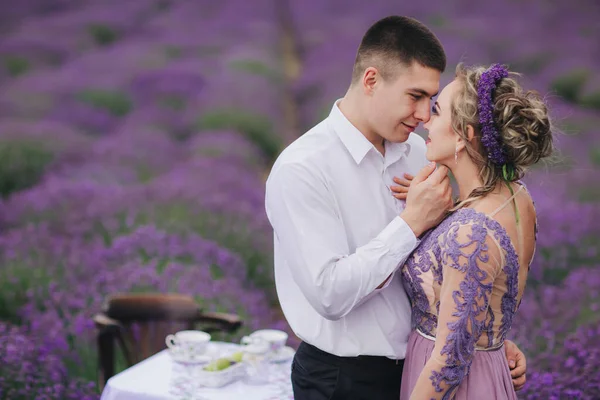 夏日阴天 年轻夫妇在薰衣草地里拥抱和散步 穿着华丽的紫色衣服和发型的女孩 — 图库照片