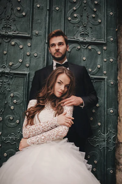 Pareja Boda Abrazos Cerca Puerta Verde Vintage Murallas Piedra Fondo —  Fotos de Stock