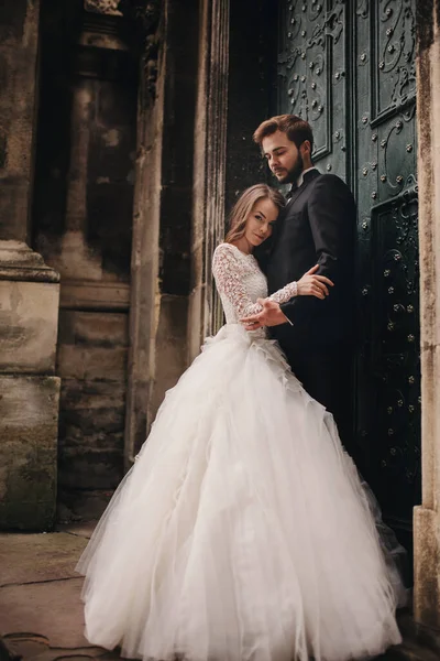 Hochzeitspaar Umarmt Sich Vor Der Grünen Tür Steinmauern Hintergrund Der — Stockfoto