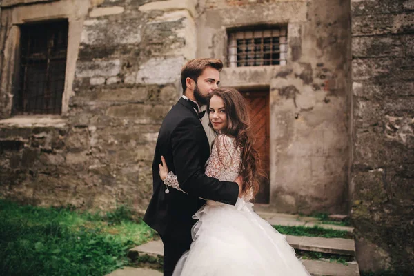 부부가 유럽의 구시가지에서 포옹과 입맞춤을 신랑과 드레스를 신부를 결혼식 — 스톡 사진