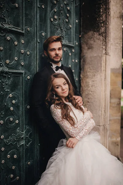 Hochzeitspaar Umarmt Sich Vor Der Grünen Tür Steinmauern Hintergrund Der — Stockfoto