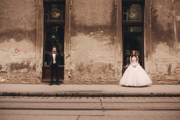 유럽의 구시가지를 산책하는 신랑과 드레스를 — 스톡 사진