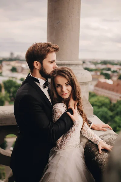 Ευτυχισμένος Νιόπαντρος Όμορφη Νύφη Και Κομψό Γαμπρό Αγκαλιάζονται Στο Μπαλκόνι — Φωτογραφία Αρχείου