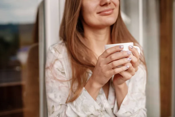 Junge Frau, die morgens nach dem Duschen auf dem Hotelbalkon steht. mit einer Tasse Kaffee oder Tee in der Hand. Außerhalb der Natur Wald und Berg — Stockfoto