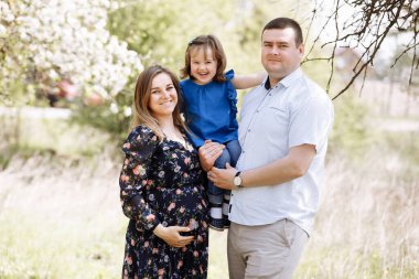 Mutlu bir genç aile yaz günü dışarıda vakit geçirir.