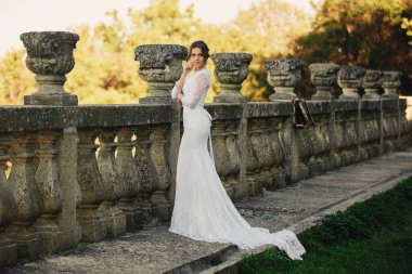 Lüks elbiseli güzel bir gelin büyük bir balkonda duruyor..