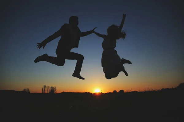 Die Silhouette Eines Jungen Paares Hüpft Und Amüsiert Sich Sommerabend — Stockfoto